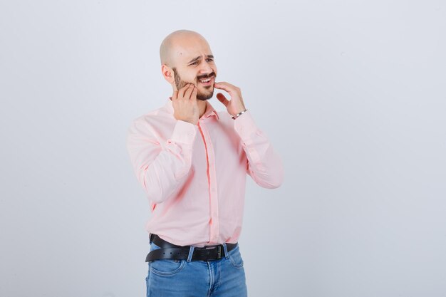 Giovane che controlla la pelle toccandosi la barba