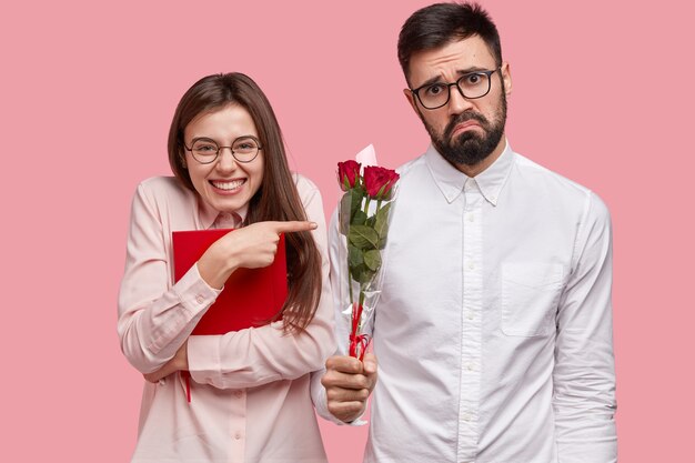 Giovane che dà mazzo di rose rosse alla donna