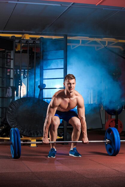 giovane che fa esercizi con bilanciere in palestra