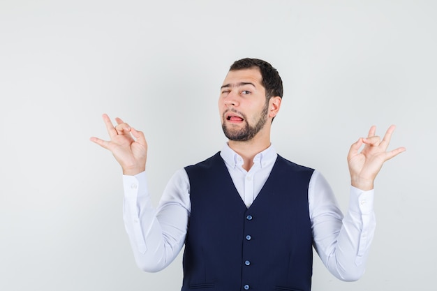 Giovane che fa meditazione e ammiccante occhio in camicia