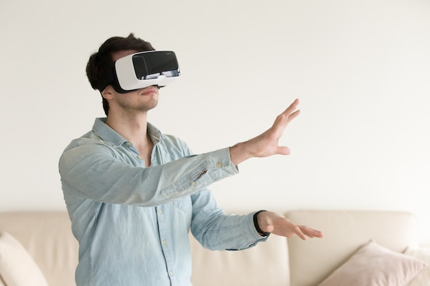 Giovane che indossa occhiali per realtà virtuale, cuffia VR per smartp
