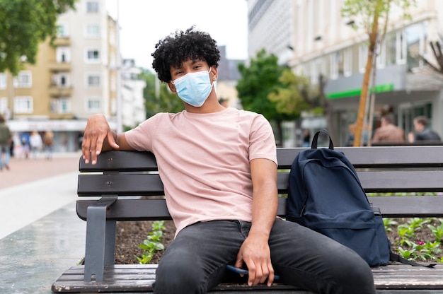 Giovane che indossa una maschera all'aperto