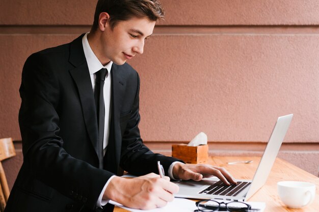 Giovane che lavora al computer portatile in ufficio