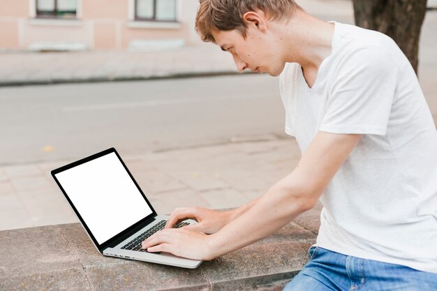 Giovane che lavora al modello del computer portatile