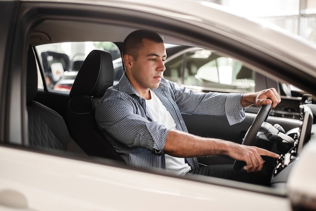 Giovane che prova un'auto alla concessionaria