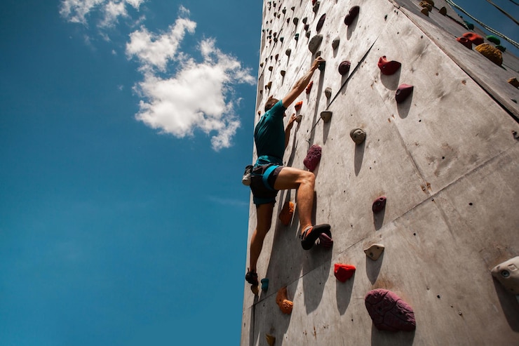 Foto gratuito giovane che si esercita in palestra di arrampicata indoor