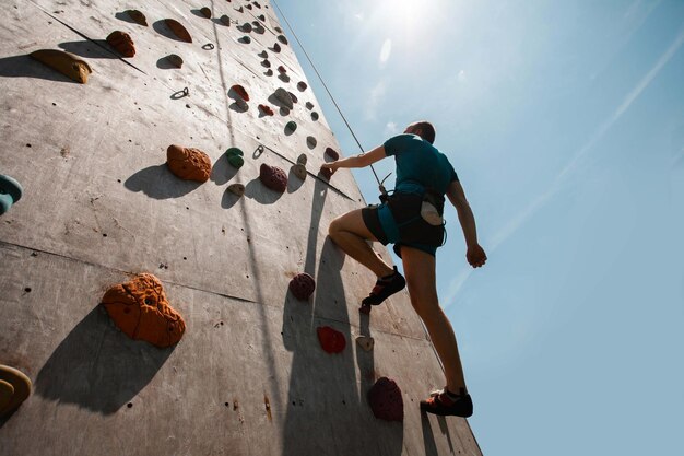 Giovane che si esercita in palestra di arrampicata indoor