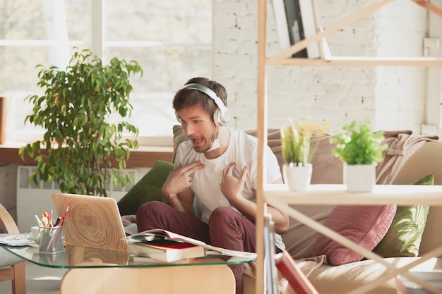 Giovane che studia a casa durante i corsi online per traduttore di architetti di marketing