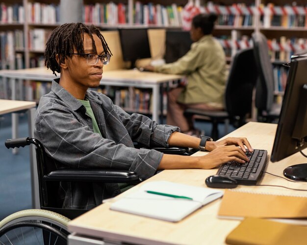 Giovane che studia nella biblioteca dell'università