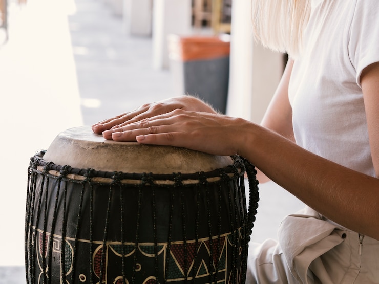Foto gratuito giovane che suona lo strumento a percussione latino