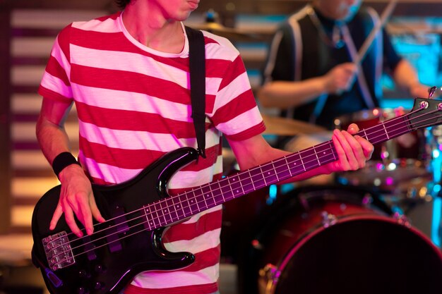 Giovane che suona musica per chitarra a un evento locale