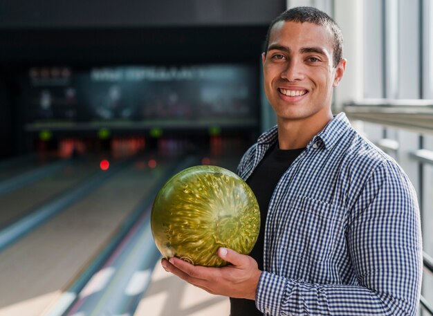 Giovane che tiene una palla da bowling dorata