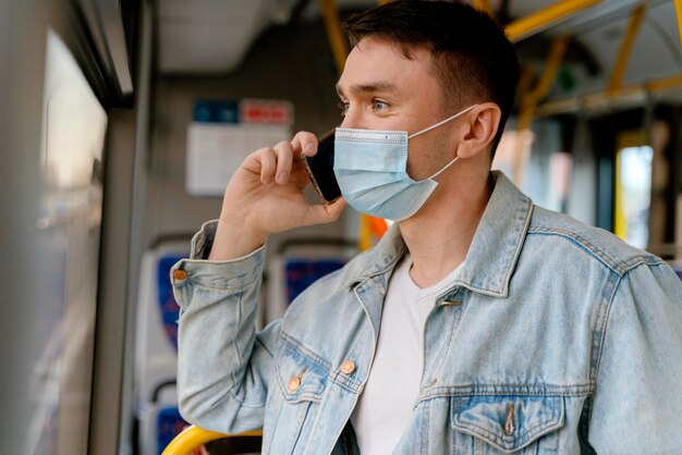 Giovane che viaggia in autobus urbano utilizzando smartphone