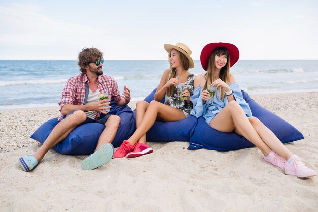 Giovane compagnia hipster di amici in vacanza al bar sulla spiaggia, bevendo cocktail mojito