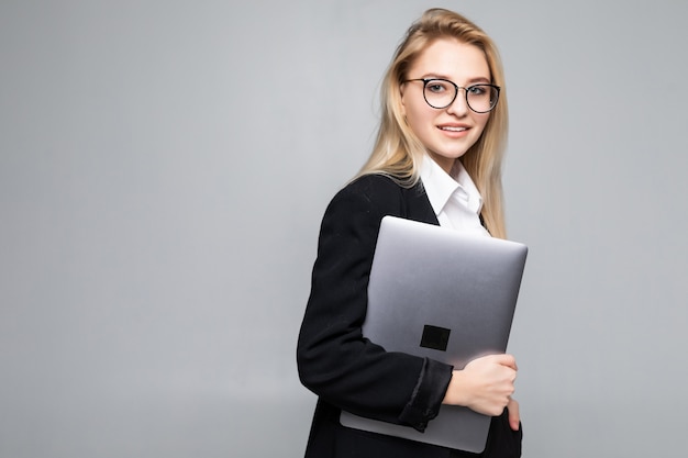 Giovane computer portatile sorridente felice della tenuta della donna di affari isolato