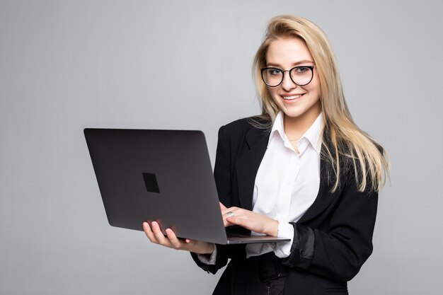 Giovane computer portatile sorridente felice della tenuta della donna di affari isolato