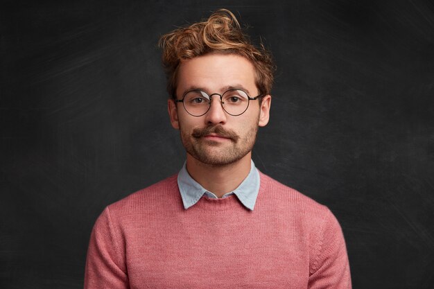 Giovane con barba e occhiali rotondi