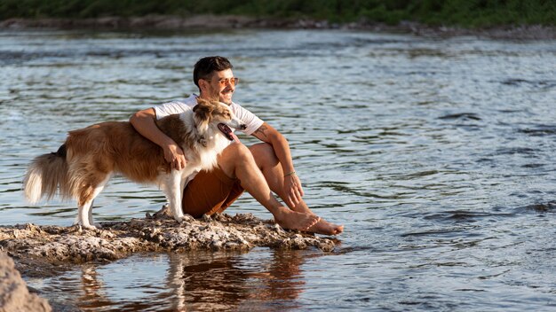 Giovane con cane in riva al mare