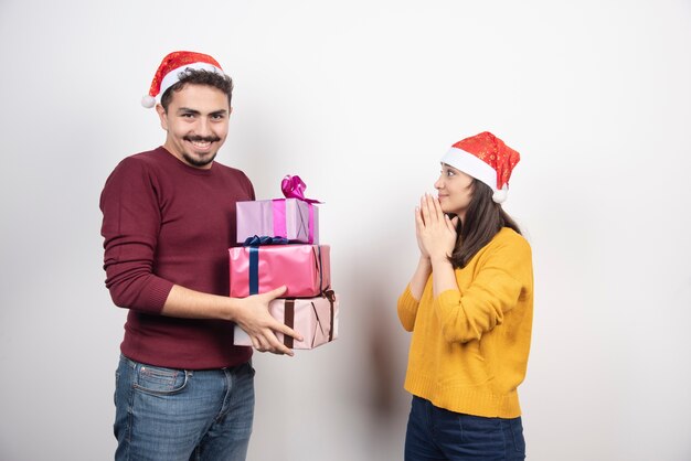 Giovane con la donna in posa con i regali di Natale.