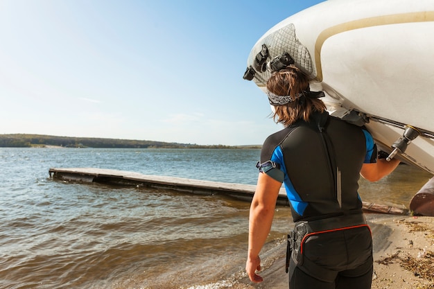 Giovane con tavola da kitesurf