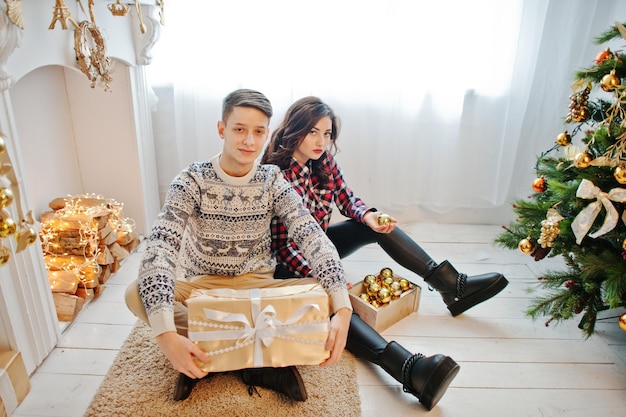 Giovane coppia alla moda con i regali di Natale e la decorazione del nuovo anno Tono di colore caldo tenue