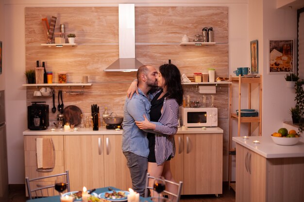 Giovane coppia che balla in cucina durante una cena romantica