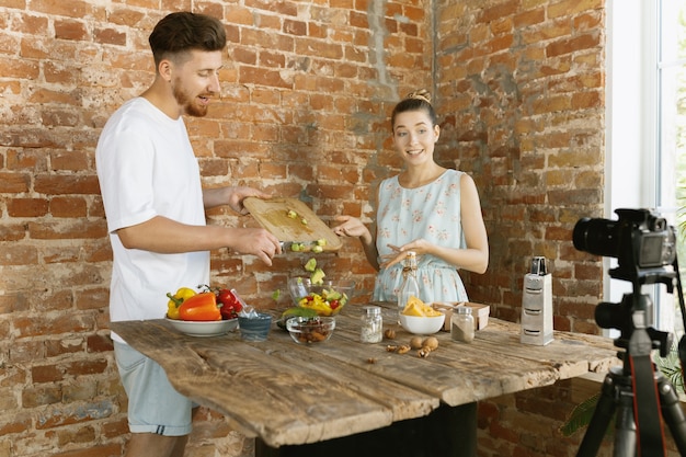 Giovane coppia che cucina e registra video dal vivo per vlog e social media