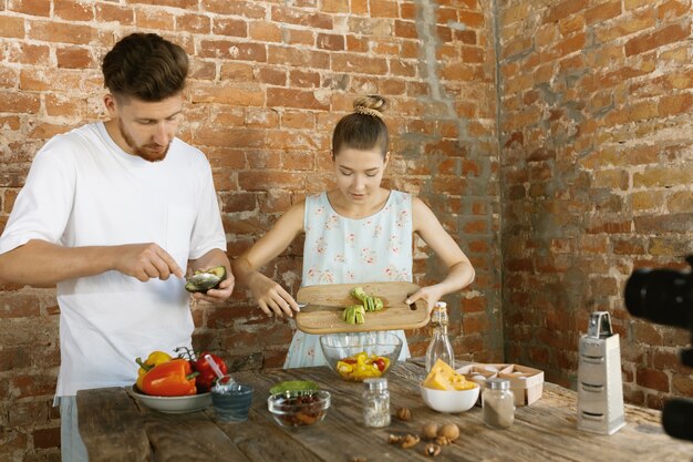 Giovane coppia che cucina e registra video dal vivo per vlog e social media