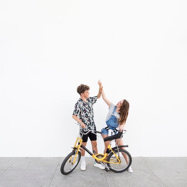 Giovane coppia con la bicicletta dando il cinque a vicenda
