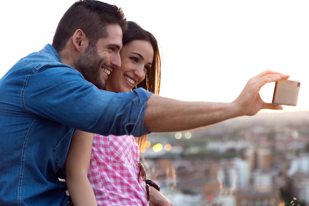 Giovane coppia di turisti in città utilizzando il telefono cellulare.