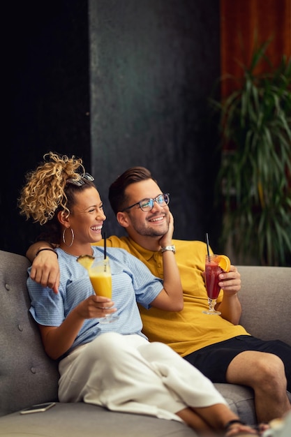 Giovane coppia felice con cocktail di frutta godendo nel loro tempo insieme