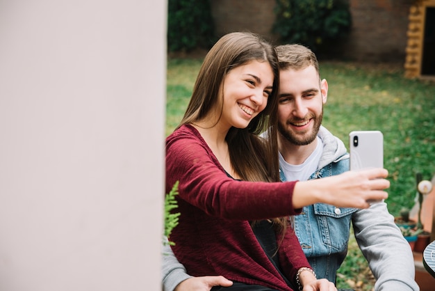 Giovane coppia in amore prendendo selfie in giardino