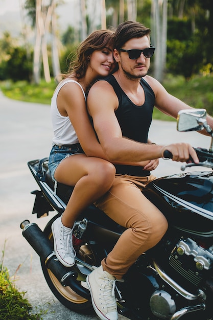 Giovane coppia innamorata, in sella a una motocicletta