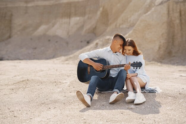 Giovane coppia innamorata, ragazzo a suonare la chitarra