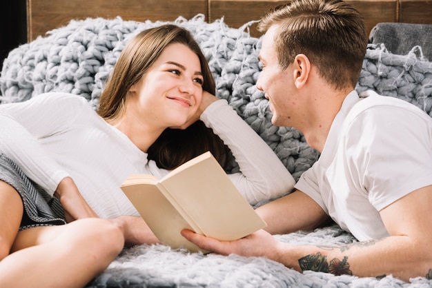 Giovane coppia lettura libro sul divano