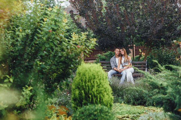 Giovane coppia seduta su una panchina al parco e guardando davanti