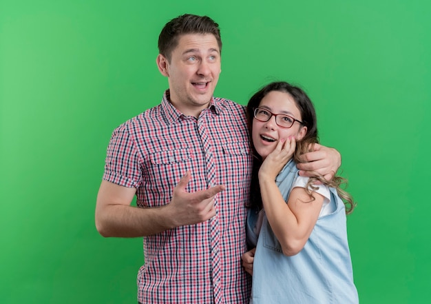 Giovane coppia uomo e donna in abiti casual insieme sorridente felice e positivo sul verde