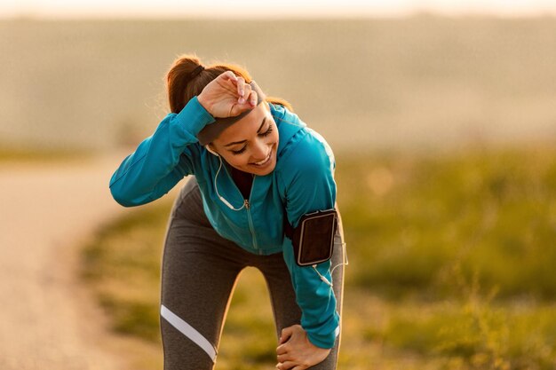 Giovane corridore femminile che si sente esausto dopo aver fatto jogging nella natura