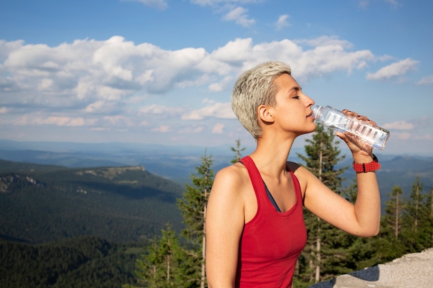 Giovane corridore femminile che tiene una bottiglia d'acqua