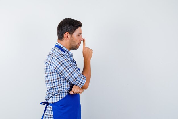 Giovane cuoco maschio in un grembiule blu e una camicia