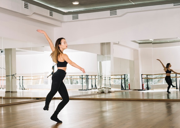 Giovane danzatore femminile che pratica nello studio di ballo