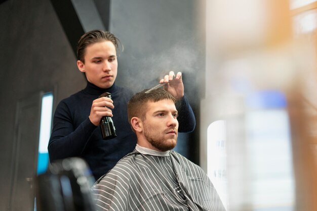 Giovane di tiro medio che si fa tagliare i capelli