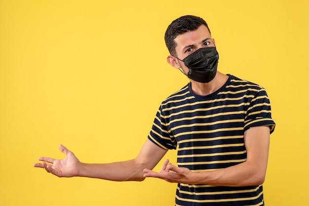 Giovane di vista frontale in posto della copia del fondo giallo della maglietta a strisce in bianco e nero