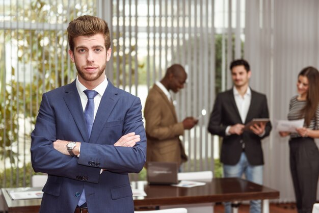 Giovane dirigente con le braccia incrociate sul posto di lavoro