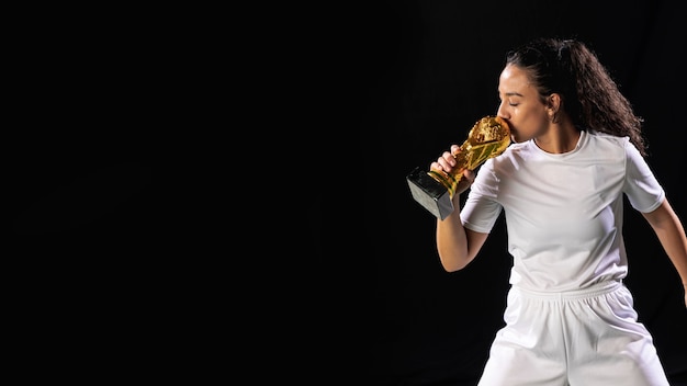 Giovane donna adatta con il trofeo di calcio