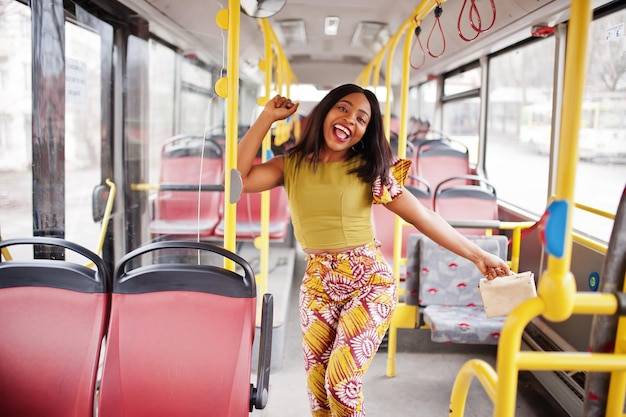Giovane donna afroamericana alla moda che guida su un autobus