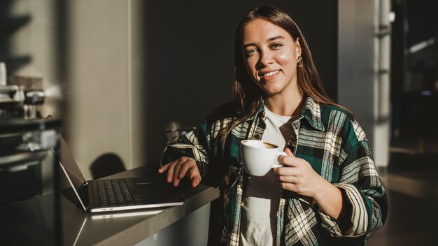 Giovane donna alla moda che gode del caffè