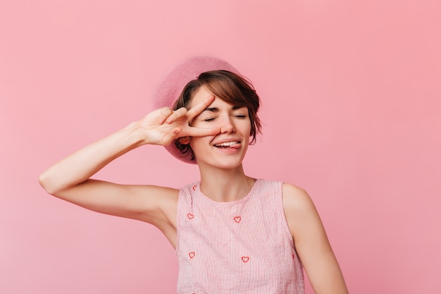 Giovane donna alla moda che mostra il segno di pace