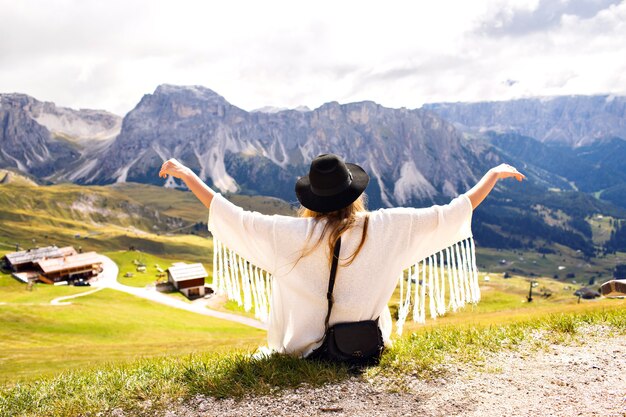 Giovane donna alla moda che propone alle montagne di Alp in abito di moda boho