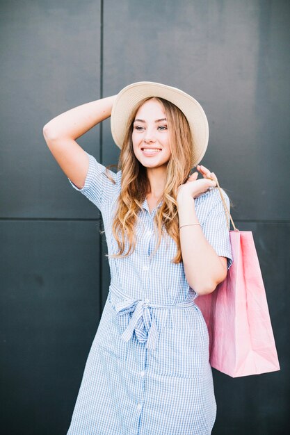 Giovane donna alla moda con sacchetti di carta rosa